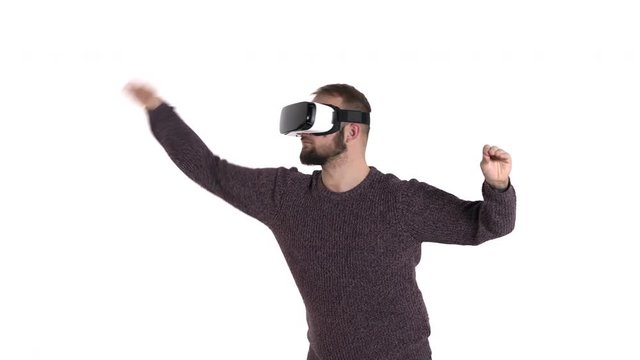Close-up demonstration of a young bearded man in VR glasses imitates orchestra conducting while listening to the music. Hi tech concept