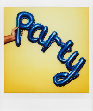 polaroid of a balloon in the shape of the word party