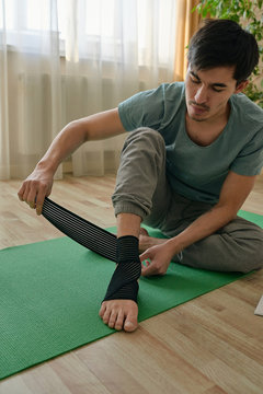 Fit man banding foot and ankle