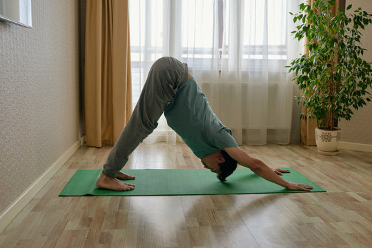 Man training asana on mat at home