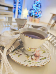 Closeup photo of cups of tee on tray with christmas tree on background