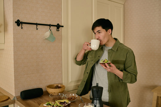 Man enjoying breakfast standing in kitchen