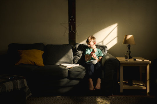 boy eating breakfast on couch