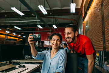Business couple taking selfie with a mobile phone