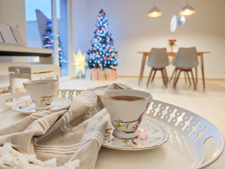 Closeup photo of cups of tee on tray with christmas tree on background