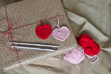 Gift boxes wrapped in craft paper, twine and knitted hearts. Modern presents for any holiday, christmas, valentine day or birthday/Close up/ Top view