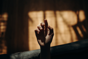 Detail of a hand reaching toward the light