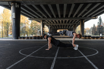 Couple doing push up plank on sports ground