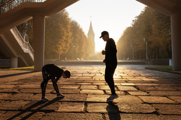 Sportive couple in city park in morning sunlight