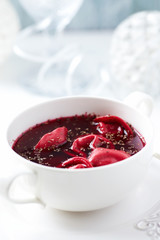 Traditional Christmas Borscht (Barszcz) with mushroom dumplingson bright background. 