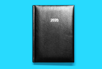 black notebook isolated on blue background 2020