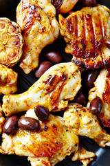 Grilled chicken pieces with kalamata olives. Top view. Close up. 