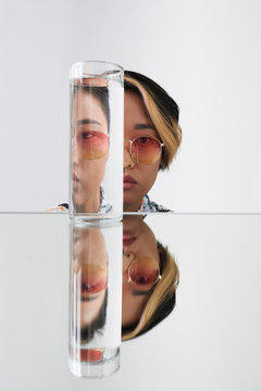 Modern woman in sunglasses through contorted glass