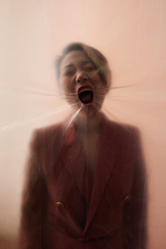 Screaming woman through plastic foil
