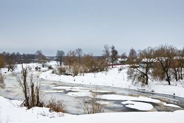 Winter Russian landscape with the river covered of ice and small village/ the river Dubna/ Dmitrov district / Moscow Region / Russia