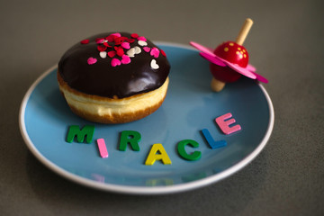 Hanukkah concept with chocolate donut and spinning top.