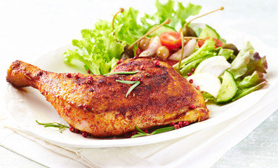 Spicy chicken leg with fresh salad. Bright background. Close up. 
