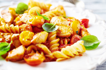 Pasta with cherry tomatoes and chicken breast. Close up.