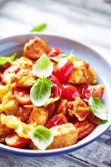 Farfalle pasta with cherry tomatoes, chicken breast and fresh basil. Close up.