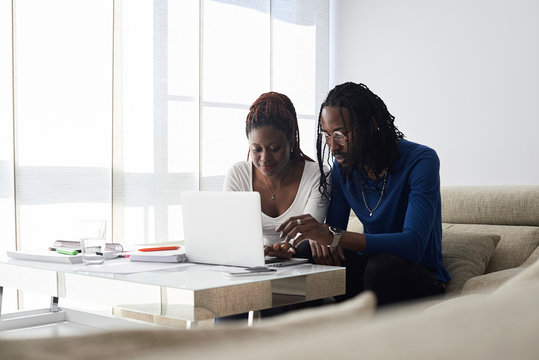 Black couple studying together home.