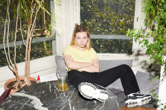 Provocative girl with legs on table