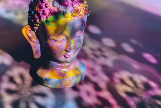 Colorful, vibrant Buddha figurine painted in bright, rich colors
