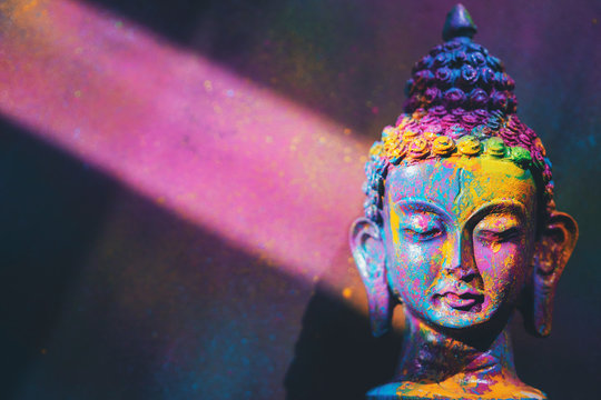 Colorful, vibrant Buddha figurine painted in bright, rich colors