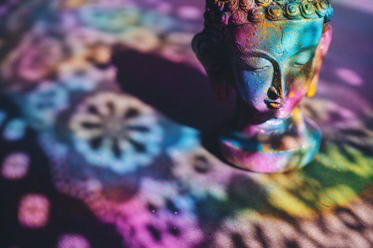 Colorful, vibrant Buddha figurine painted in bright, rich colors