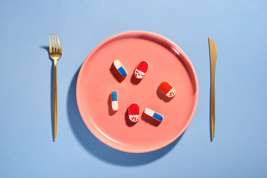 Pills on plate with fork. Pill instead of food.