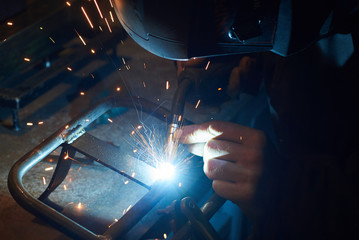 A man in a protective mask carries out welding work.