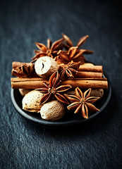 Christmas spices (star anise, cinnamonon and nutmeg) on dark stone background. Close up. 