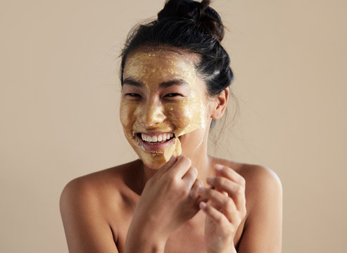Woman using skincare gold face mask