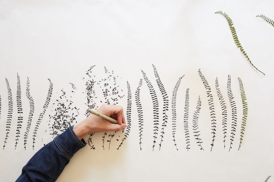 Artist drawing leaves patterns on paper