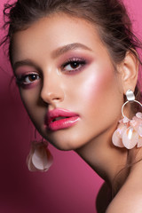 Fashion portrait of a beautiful girl with trendy pink makeup, accessories and background. Brunette model with hazel eyes