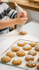 Cute boy decorating holiday gingerbread cookies at home kitchen