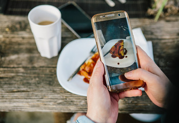 A woman photographing her slice of cake