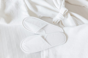 White and fresh bathrobe and slippers, top view