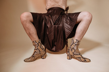 Crop crossdresser in skirt and snake leather boots