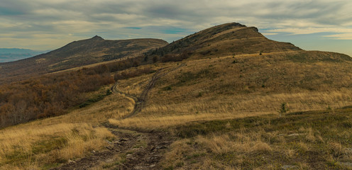 Carpathian Mountains landscape photography highland plateau with dirt trail and rocky cliffs background in moody cloudy weather