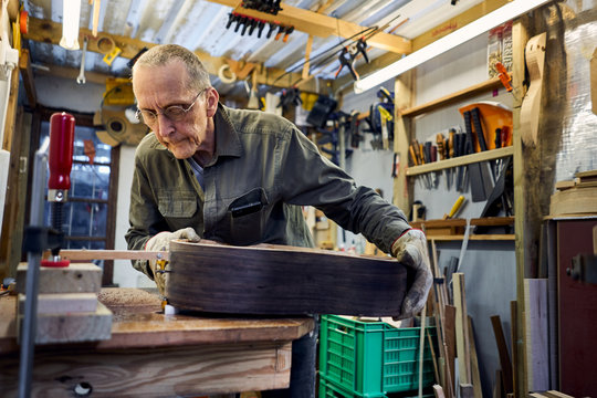 craftsman making a guitar in his woodwork workshop