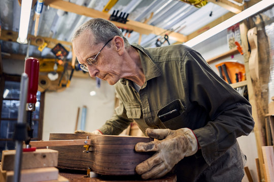 craftsman making a guitar in his woodwork workshop