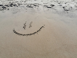 Smile on the sand.Smile face on sand.Smiley face in the sand on a beach.