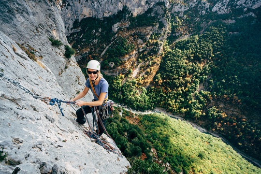 Rock climber high on a steep mountain cliff