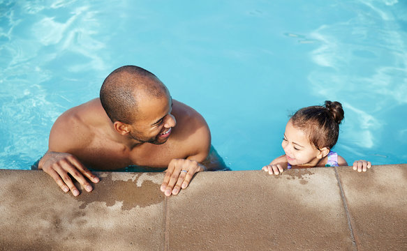 African American father teaching his daughter how to swim
