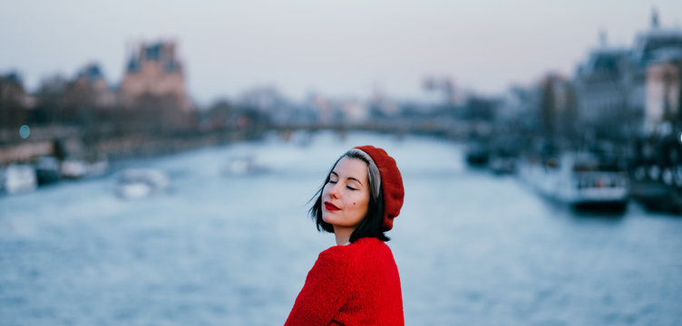 young woman dressed in red contemplating the river Sena