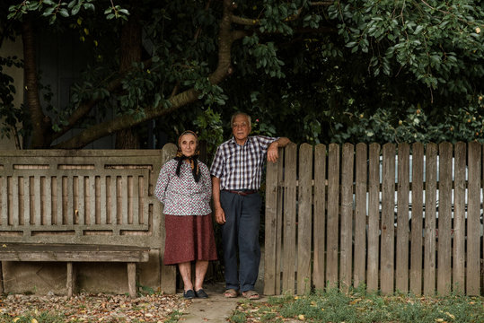 Old married couple in gates of rural house