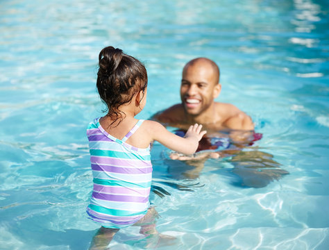 African American father giving his daughter a swim lesson