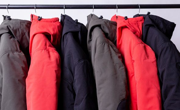 family concept or showroom of down jacket winter parka hanging on a hanger in the wardrobe
