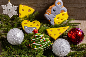 Gingerbread cookies on a background of Christmas tree branches and Christmas decoration. Christmas background. Symbol of 2020: a Rat. 