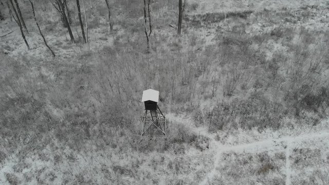 Aerial view on raised hide on frozen meadow covered by snow.